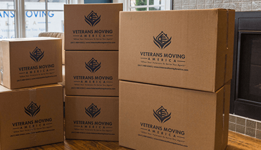 Stacked Veterans Moving America packing boxes ready for a move