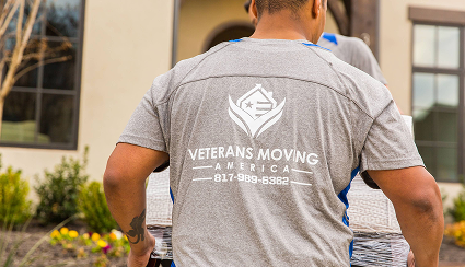 Veteran movers carrying wrapped furniture into a home